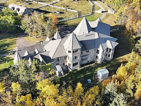 Vista aérea de la residencia de piedra rodeada de bosque en Alberta